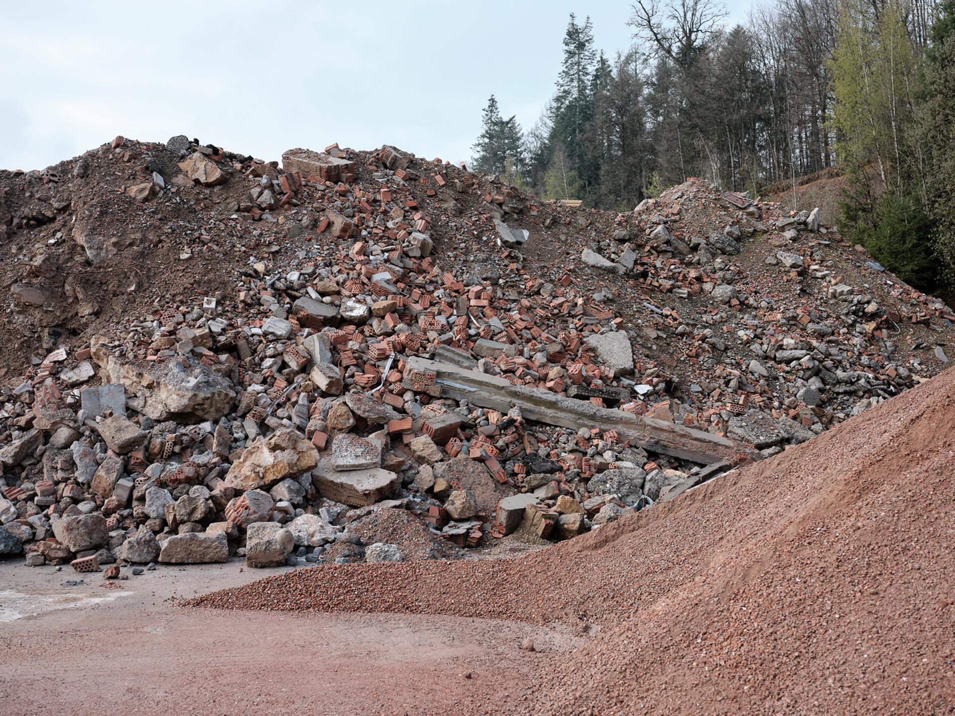 Haufenweise recyclebare Ziegelsteine und Mauer-Stücke: Eine Deponie von Vigier Beton. 