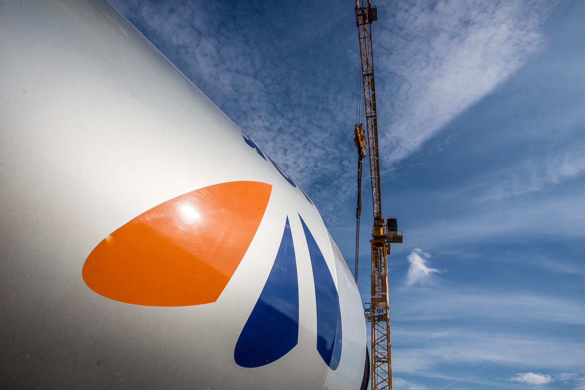 Ein Betonmischer und ein Kran von unten fotografiert. Man sieht hauptsächlich blauen Himmel.