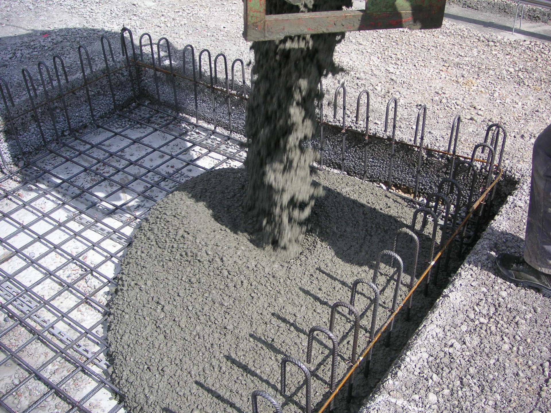 Beton fliesst in eine quadratisches mit Stahlträger verstärktes Becken. 