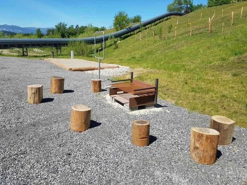 Eine Feuerstelle mit einigen baumstamm-Hocker auf einem Betonboden.